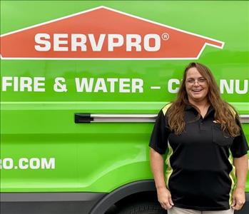 female employee standing next to a SERVPRO vehicle